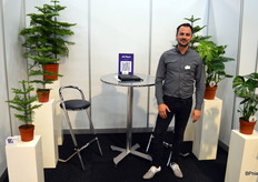 Joram Kuijvenhoven van JK Plant, geflankeerd door Auracaria's en Monstera's in verschillende potmaten